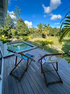 une terrasse avec deux chaises et une piscine dans l'établissement Cottage Saudade - Les Terres Basses, à Marigot