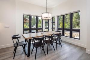 uma sala de jantar com mesa, cadeiras e janelas em Suncadia Trailhead 2 Condo 308 em Cle Elum