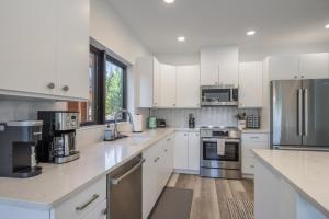 una cucina con armadietti bianchi ed elettrodomestici in acciaio inossidabile di Suncadia Trailhead 2 Condo 108 a Cle Elum