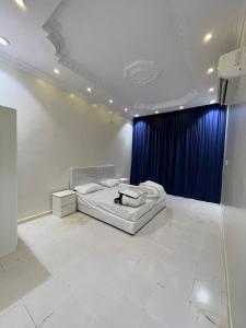 a bedroom with a bed and a blue curtain at شاليه الفوز 2 in Al Madinah