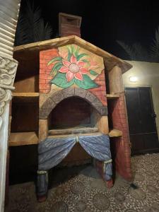 ein Spielhaus mit einem gemauerten Kamin und einer darauf gemalten Blume in der Unterkunft شاليه الفوز 2 in Medina