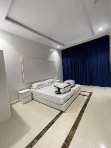 a bedroom with a bed and a blue curtain at شاليه الفوز 2 in Al Madinah