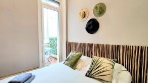 sypialnia z łóżkiem i zegarem na ścianie w obiekcie KOSY Spa, Les Princes w Cannes