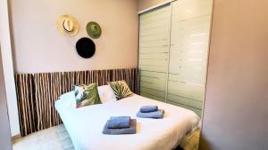 sypialnia z łóżkiem i dwoma ręcznikami na nim w obiekcie KOSY Spa, Les Princes w Cannes