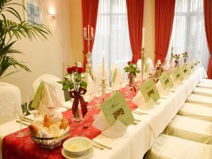 ライプツィヒにあるバランス ホテル ライプチヒ アルテ メッセの白いテーブルクロスと花の長いテーブル