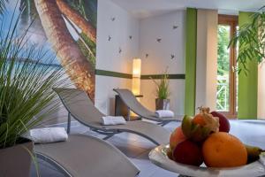 ライプツィヒにあるバランス ホテル ライプチヒ アルテ メッセの椅子と果物の盛り合わせが備わる客室です。