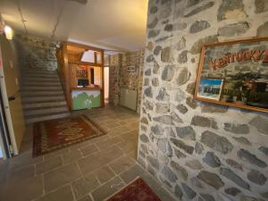 um quarto com uma parede de pedra e uma escada em HOTEL ITALIA em Forni di Sopra