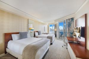 a hotel room with two beds and a balcony at 15th Floor Luxury Suite at Trump Int Resort in Sunny Isles Beach