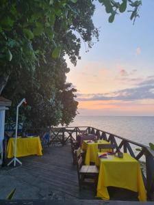 two tables with yellow table cloths on the beach at Sky Beach Rooms in Lucea