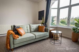 uma sala de estar com um sofá e uma mesa em New! Stylish 2 bed flat with parking near beach - Parkstone Central em Parkstone