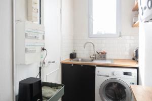 een wasruimte met een wastafel en een wasmachine bij Cozy 30 m love nest in Levallois-Perret in Levallois-Perret