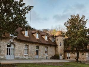 Cernay-la-Ville的住宿－德沃塞爾奈修道院酒店，屋顶上有一个钟的旧砖砌建筑