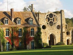 an old stone building with a large window at Abbaye Des Vaux De Cernay in Cernay-la-Ville