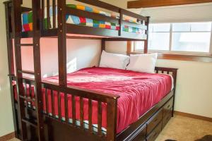 a bedroom with a bunk bed with a red bedspread at Great Location Near Pool with Suncadia Pool Access in Cle Elum +23 photos