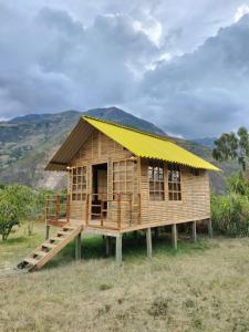 una pequeña casa de madera con techo amarillo en Hotel Campestre Cabañas de la Sierra Nevada de El Cocuy, en Panqueba