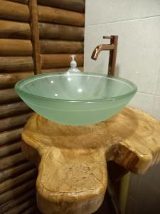 a bathroom with a glass sink on top of a wooden table at Hotel Campestre Cabañas de la Sierra Nevada de El Cocuy in Panqueba
