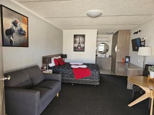 een hotelkamer met een bed en een bank bij Cameo Inn Motel in West Wyalong