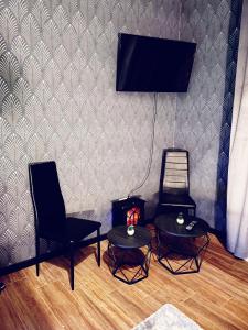 にあるNUESTRA SEÑORA DEL PINARの壁にテレビと椅子2脚が備わる客室です。