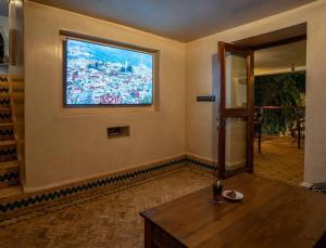 una sala de estar con una gran ventana en la pared en Hotel Molino Garden, en Chefchaouen