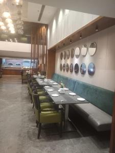 a long row of tables and chairs in a restaurant at Hotel Comfortel Banjara Hills- Free Buffet breakfast- Multi Cuisine Restauran- An Svm Brand in Hyderabad