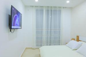 Schlafzimmer mit einem Bett und einem Flachbild-TV in der Unterkunft 3 bed Akid Lotfi with parking in Bir el Djir