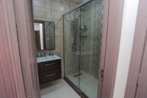 ein Bad mit einer Glasdusche und einem Waschbecken in der Unterkunft 3 bed Akid Lotfi with parking in Bir el Djir