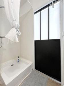 a white bathroom with a tub and a window at Alger Lodge in Nantes
