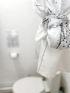 a white towel is tied around a toilet at Alger Lodge in Nantes