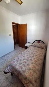 um quarto com uma cama com um edredão floral em La casa de la Nona em San Rafael