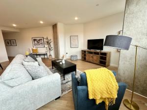 sala de estar con sofá y TV en Nimitz Crossing Luxury Residences, en San Diego