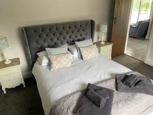 1 dormitorio con 1 cama grande y cabecero grande en The Stables, en Hereford
