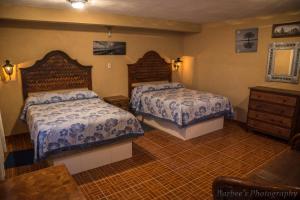 a bedroom with two beds and a dresser at MARGARITA Hotel in San Miguel de Allende