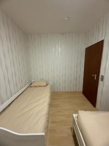 um pequeno quarto com duas camas e uma porta em HomeStay em Bochum