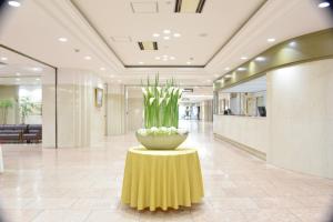 un vestíbulo con un jarrón de flores sobre una mesa en HOTEL NEWITAYA en Utsunomiya