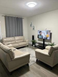 sala de estar con 2 sofás y TV de pantalla plana en Docker, en Timberlea