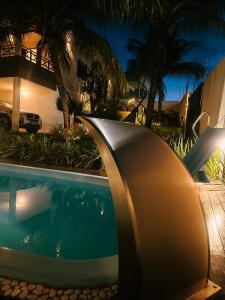 una piscina frente a una casa por la noche en Casa dos Girassóis, en Pipa