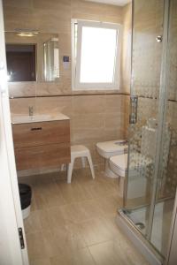 a bathroom with a toilet and a sink and a shower at Hotel Roca Bella in Es Pujols