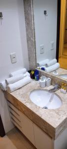 uma casa de banho com um lavatório e um espelho grande em The Sun Resort - Super Apartamento de 2 quartos - 1 suíte e 1 reversível em Brasília
