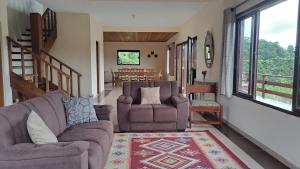 a living room with two chairs and a rug at Casa Sossego na Montanha in Campos do Jordão