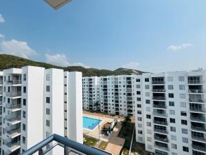 an apartment building with a swimming pool in the foreground at Aqualina Orange Girardot, décimo piso in Girardot