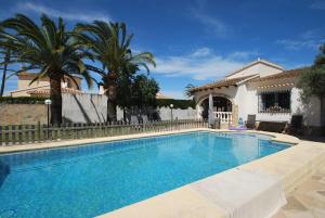 ein Swimmingpool vor einem Haus mit Palmen in der Unterkunft Villa Vista Segaria in El Verger