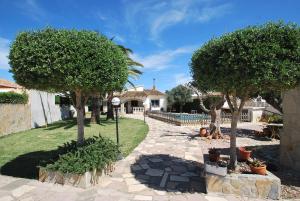 einen Garten mit zwei Bäumen und einem Steinweg in der Unterkunft Villa Vista Segaria in El Verger