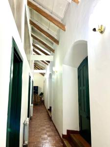 a hallway with white walls and a green door at Contando Historia in Potosí