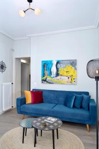 - un canapé bleu dans le salon avec une table dans l'établissement Acropolis Unique 2BD Apartment with Prive Entrance, à Athènes