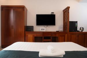 a bedroom with a bed with a television and a desk at Twins Hotel in Ho Chi Minh City