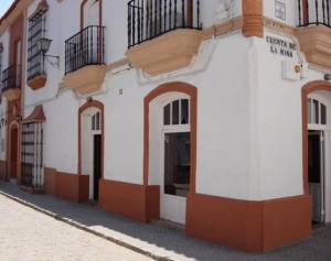a white building with balconies on a street at Hotel Don Juan in El Coronil