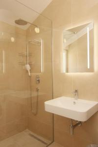 y baño con ducha, lavabo y espejo. en Apartman Mimoza, en Budva