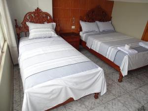 duas camas sentadas uma ao lado da outra num quarto em Hostal Ucayali em Tingo María