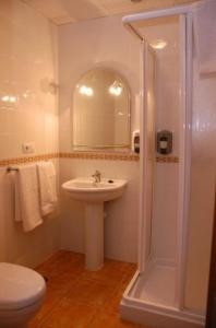uma casa de banho com um lavatório, um chuveiro e um WC. em Hotel Don Juan em El Coronil