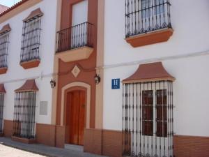 um edifício com barras nas janelas e uma porta em Hotel Don Juan em El Coronil